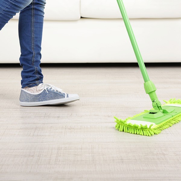 Woman with mop cleaning wooden floor from dust Woman with mop cleaning wooden floor | New York Carpets & Flooring